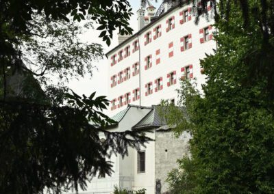 Schloss Ambras vom Garten aus mit Bäumen