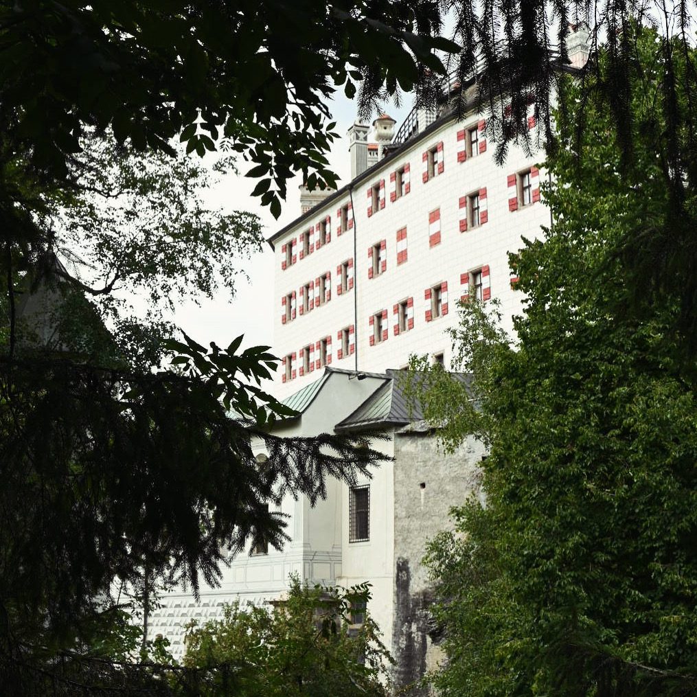 Schloss Ambras vom Garten aus mit Bäumen